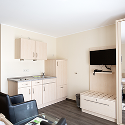 Küchenzeile im Doppelzimmer mit Kühlschrank, Spüle und Sitzbereich