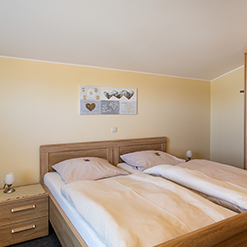 Doppelzimmer ohne Küche mit Bett und heller Einrichtung