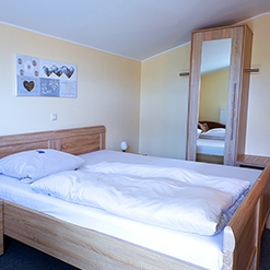 Einzelzimmer ohne Küche mit Bett und Kleiderschrank